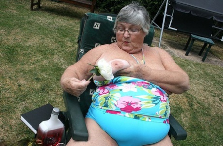 Granny Libby, who is an unhinged lad in the garden, placing a bottle inside her large vagina.