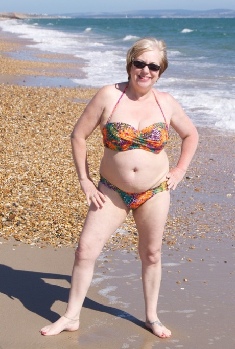 Mature UK Woman Speedy Bee Wears Sunglasses While Getting Naked At The Beach