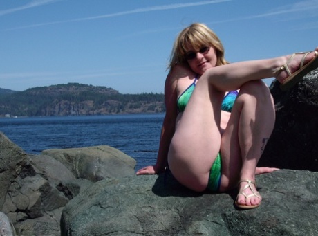 Middle-aged amateur Cougar Babe Lolee removes her bikini on a rocky shoreline