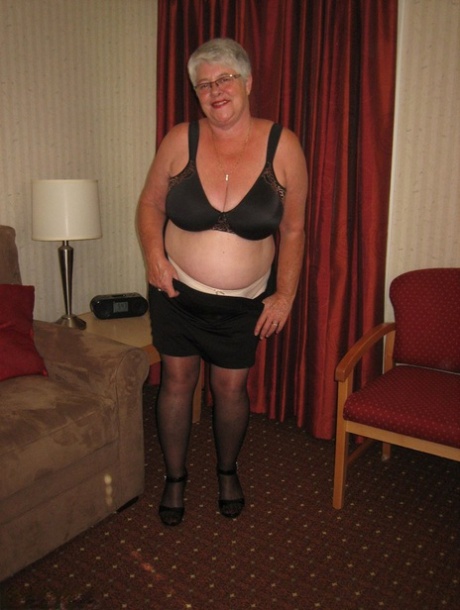 Fat Granny Girdle Goddess dons a black slip and coverall with an upskirt that is not pantomized.