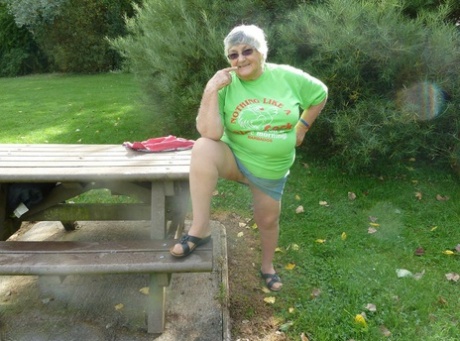 An unconscious Grandma Libby exposes her large breast and buttocks on a picnic table.