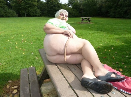 Libby, the elderly woman, exposes her massive stomach and buttockbone on a picnic table.