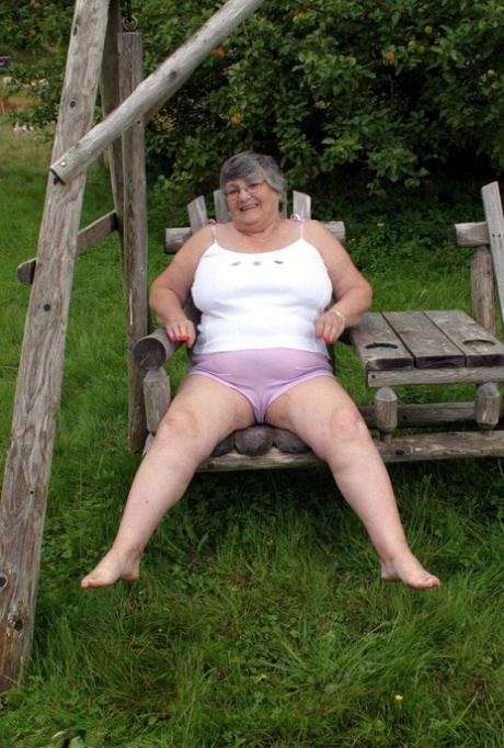 On a bench swing in the backyard, Grandma Libby showcases her breasts as an elderly British woman.
