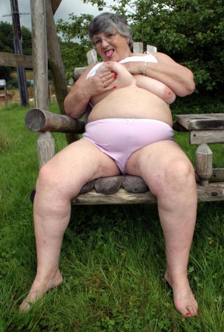 In the backyard, Grandma Libby showcases her chest muscles on a bench that she swings.