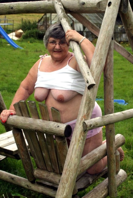 Grandma Libby, an elderly Briton, flaunts her breasts on a bench in the backyard.