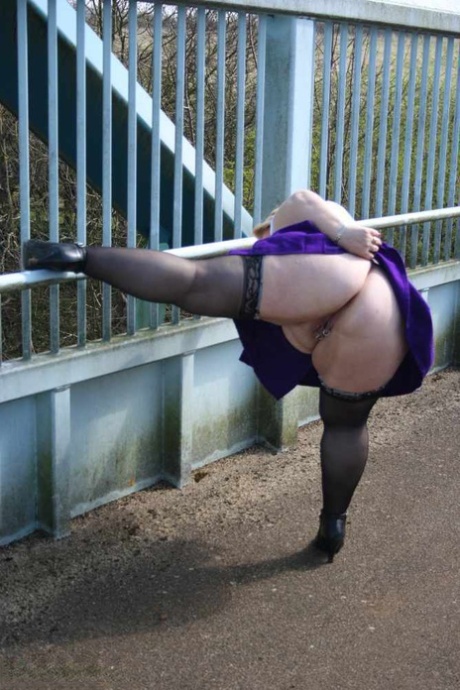 A British amateur athlete named Lexie Cummings licks her breast before crossing a footbridge.