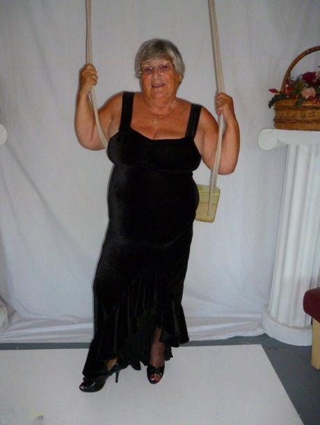 Modeling naked in stockings, Grandma Libby removes her clothing from a black dress.