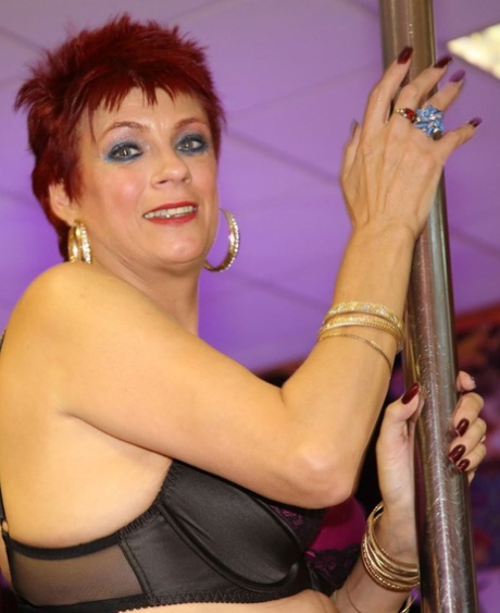 Middle-aged Woman Dimonty Sports Short Red Hair While Working A Stripper Pole