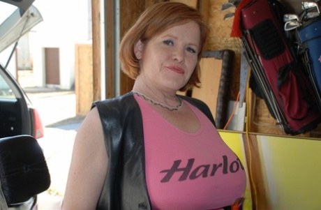 Exhibiting her big tits and exposed buttocks on a motorcycle, Misha MILF, an older female with red hair, is the subject of conversation.