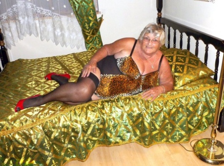 Taking on the role of an old amateur, Grandma Libby grabs a big black dildo from the bed.