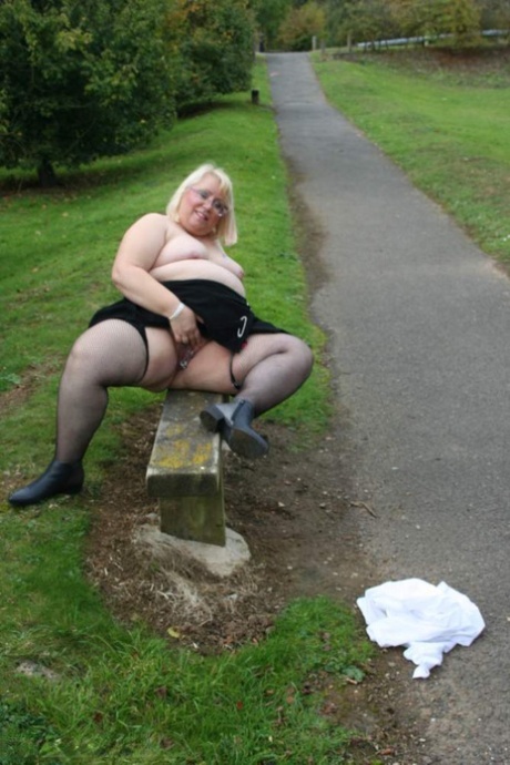 Bum, dandy butt: Big anaesthetic! This is Lexie Cumming's face as she sits on a park bench in nylons with her breasts and big buttocks showing.