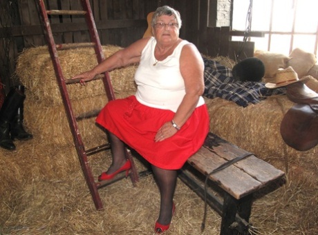 Naked in stockings on a straw bed, Grandma Libby is an elderly British woman.