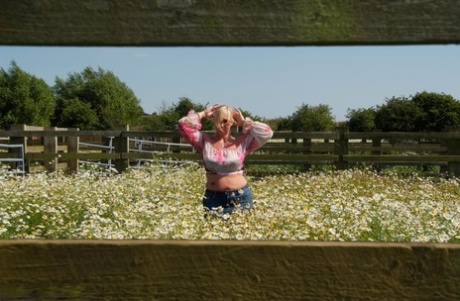 The overweight blonde, Melody, unclogs her large breasts in a field of wild flowers.