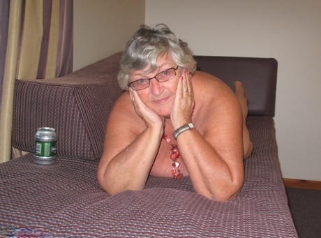 Grandmother Libby, who is fat and from the UK, exposes her breast tissue on an outdoor balcony.