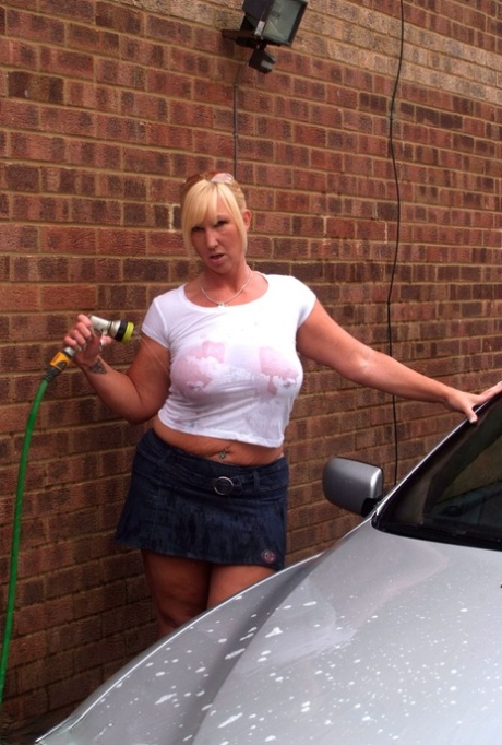 In the process of washing her car, Melody, a heavily colored blonde amateur with big tattoos, soaks in a white T-shirt.