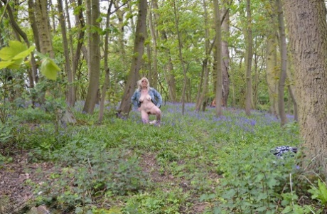 Unconventional blonde Barby Slut goes for a naked walk in the woods amid wild flowers.
