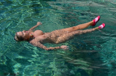 A blonde woman named Chrissy, who is busy with work, takes off from her speed boat without clothes to expose her thick naked body.