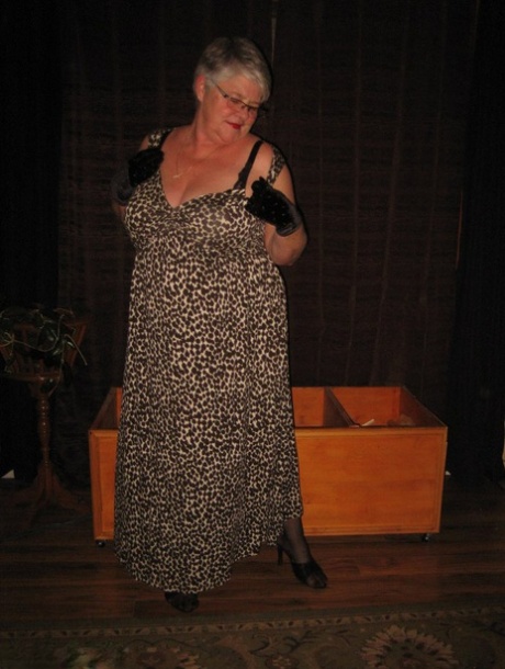 A silver-haired, buff-haired granny girdle Goddess exposes herself in black stockings and gloves.