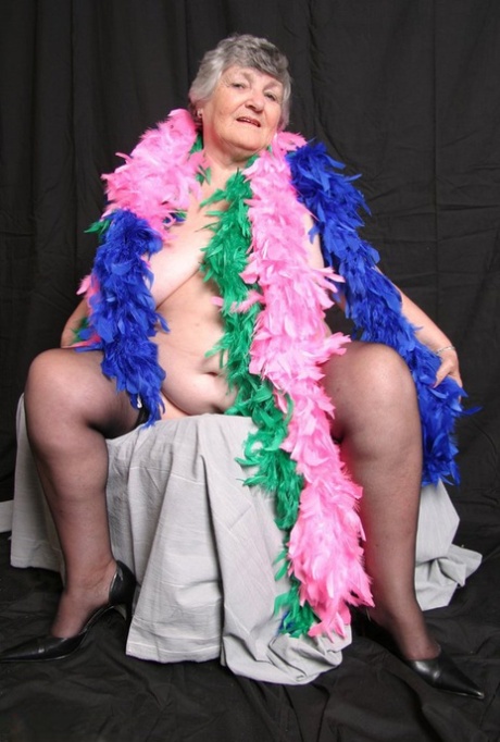 UK amateur Grandma Libby, who is fat and shows her big tits while wearing feather boas.