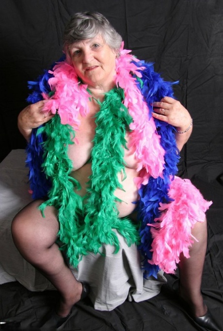 Grandma Libby, the fat amateur from Britain displays her big tits while wearing feather boas.