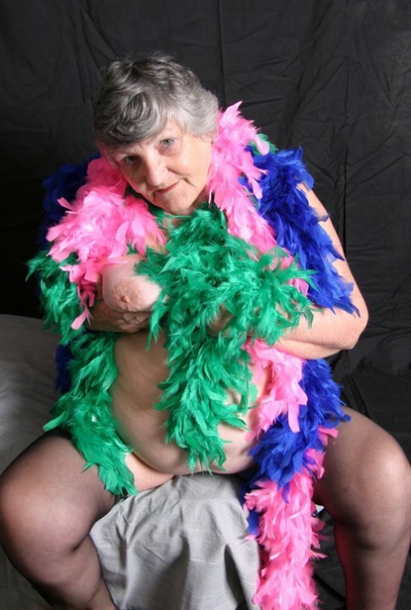 The Big Tits: Fat UK amateur Grandma Libby, who is dressed in feather boas, shows off her big tits.