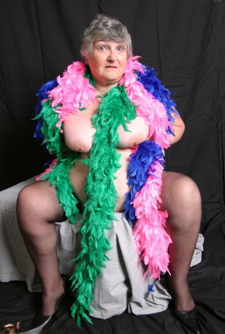 In the UK, Grandma Libby, who is fat and amateur, displays her large breasts with feathered boas to show off her big tits.