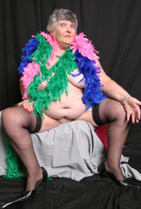 Grandma Libby, who is overweight in the UK and dressed in feather boas, displays her big tits.