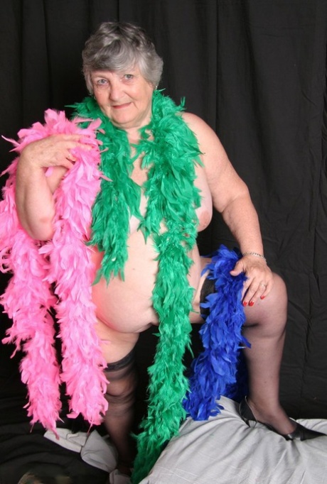While wearing feather boas, overweight UK amateur grandma Libby flaunts her large thighs.