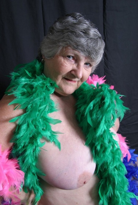 With her big tits draped over feathers, Grandma Libby from the UK flaunts her plump body.