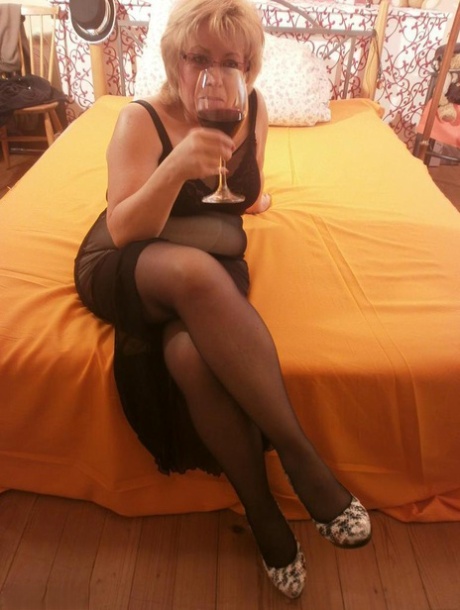 With her tipsy hot body language, granny Caro spread her legs on the bed in black stockings.