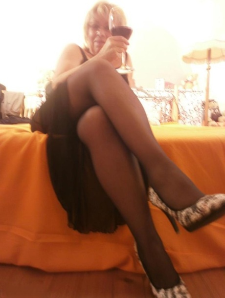 With her tipsy hotness, granny Caro spread out on the bed in black stockings.