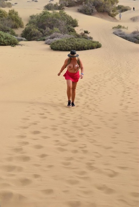 Dressed in nothing, the amateur rapper BBW Naughty walks along a beach.