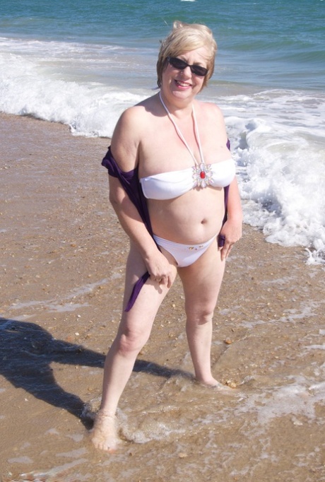 Mature amateur Speedy Bee gets naked in shades on a British beach