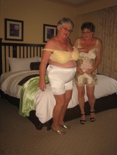 An overly active female Girdle Goddess and her horny companion strip down to stimulate their firm buttocks.