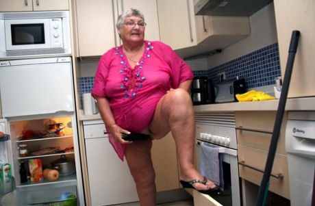 As she cleans her kitchen with her fat husband, Grandma Libby is stripped down to her nakedness.