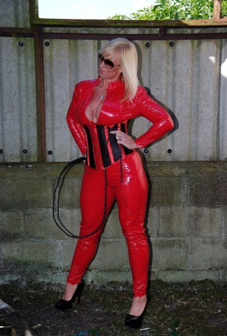 Exquisitely hot adult blonde Melody uses a whip as she unwraps her hands on the back of red latex clothing.