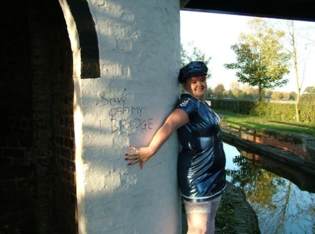 In a police uniform, Valgasmic Exposed, an old redhead, exposes herself near the mouth of a canal.