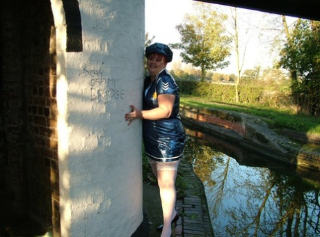 By means of a police uniform, Valgasmic Exposed, an older redhead, exposes herself by the side of a canal.