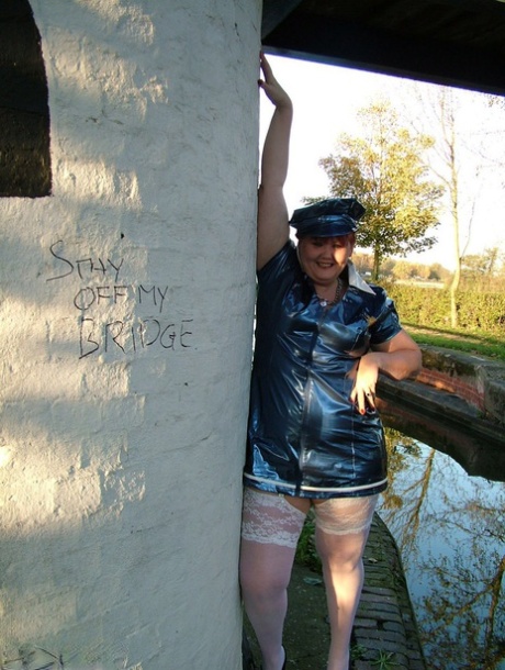 Valgasmic, an older redhead who is prone to social awkwardness, exposes herself in a police uniform by a canal.