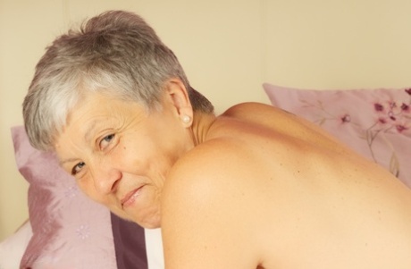 Short Haired UK Granny Savana Uncovers Her Large Tits On A Bed In A Thong