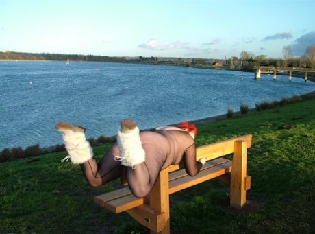 In a park, Redhead Valgasmic Exposed is seen wearing a crotchless stocking and playing with a toy.