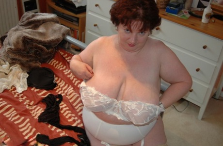 Obese woman with red hair Chris 44g sets forth her giant tits in her underwear