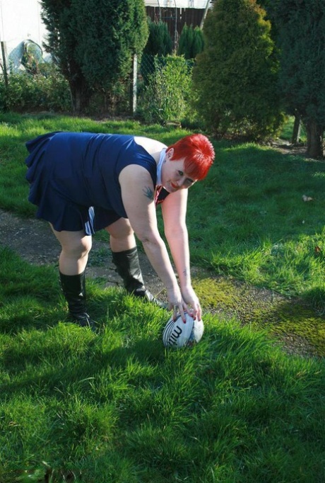 Fat and nerdy redhead Valgasmic Exposed displays her stomach while playing with a football.