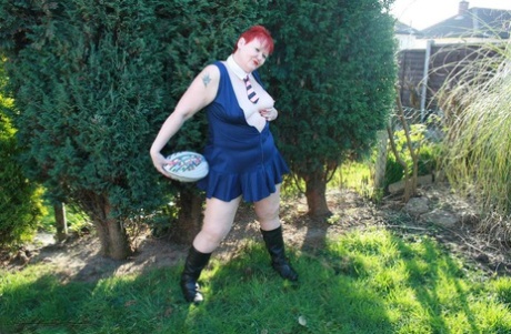 Despite being overweight, Valgasmic Exposed displays her breasts while using a football to play.