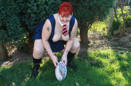 With a football in hand, Valgasmic Exposed showcases the fat redhead's stomach and breasts.