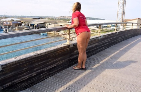 Chrissy, who is still young and fatty, walks by the sea with her large breasts on display.