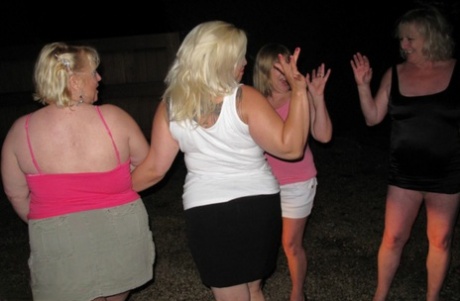 Older females who are overweight participate in group sex activities on car bonnets.