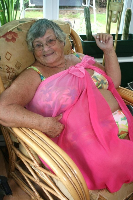 The horny elderly woman in glasses removes her clothing to expose massive tits and large BBW asses.