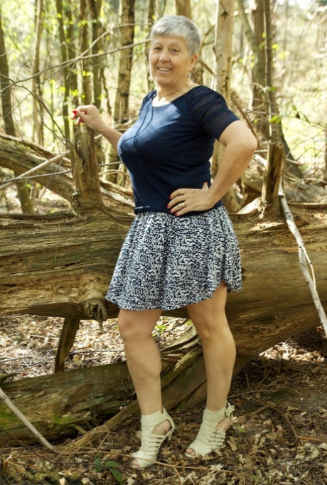 A bold old granny named Savana showcases her enormous boobs while in the wooded area.