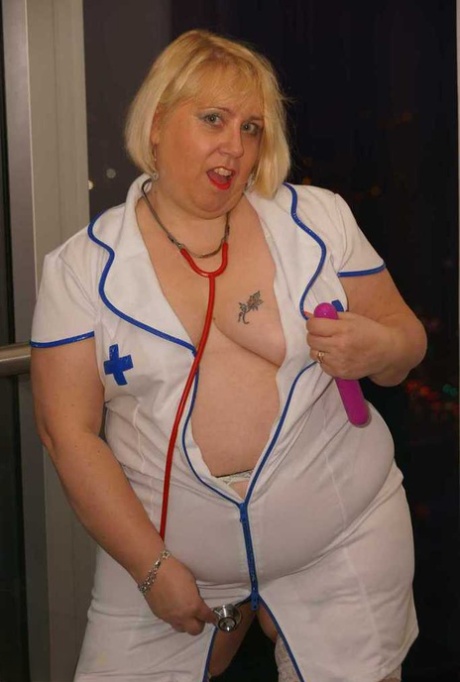 A woman who is obese and blonde, nurse Lexie Cummings, masturbates on a sofa with an electronic vibrator.